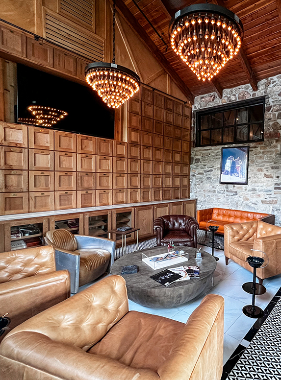 a room with a stone wall and a chandelier