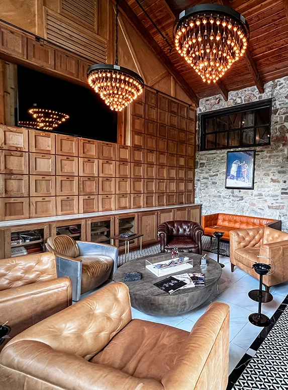 a room with a stone wall and a chandelier