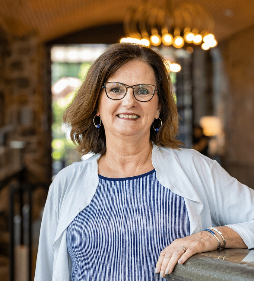 a woman wearing glasses and a white cardigan