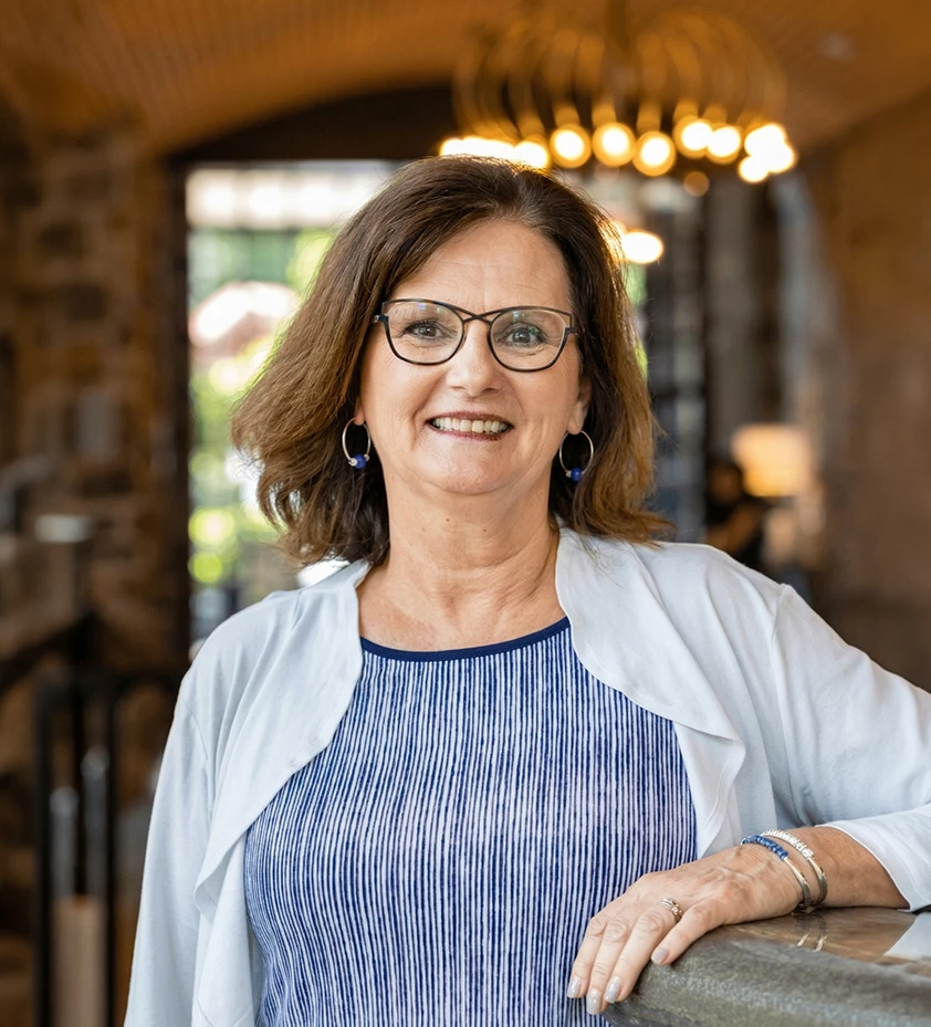 a woman wearing glasses and a white cardigan