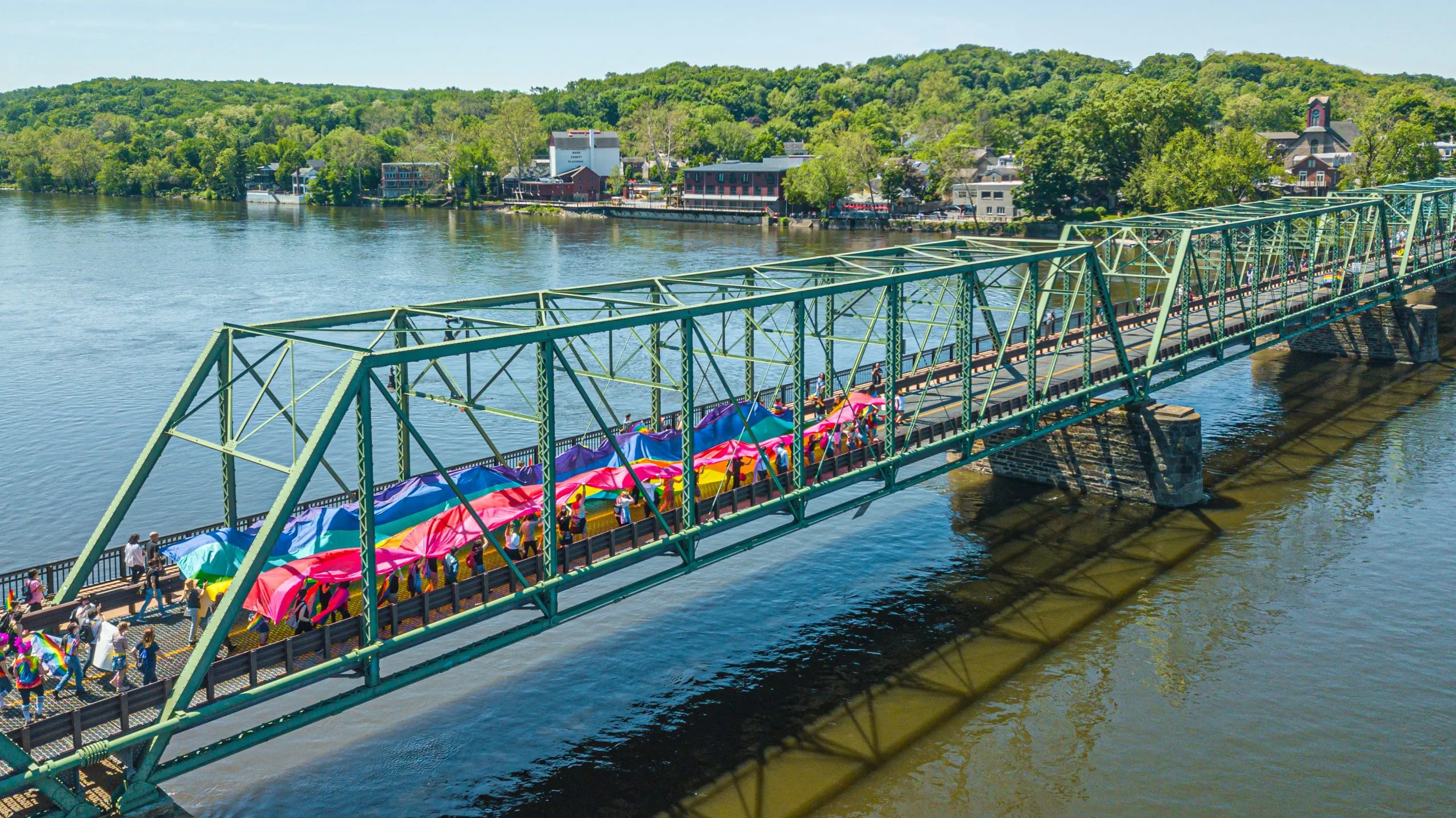 a bridge with a group of people carrying a large colorful object