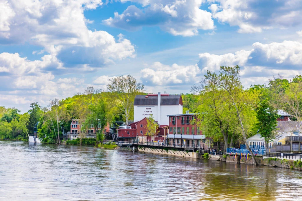 a river with trees and buildings