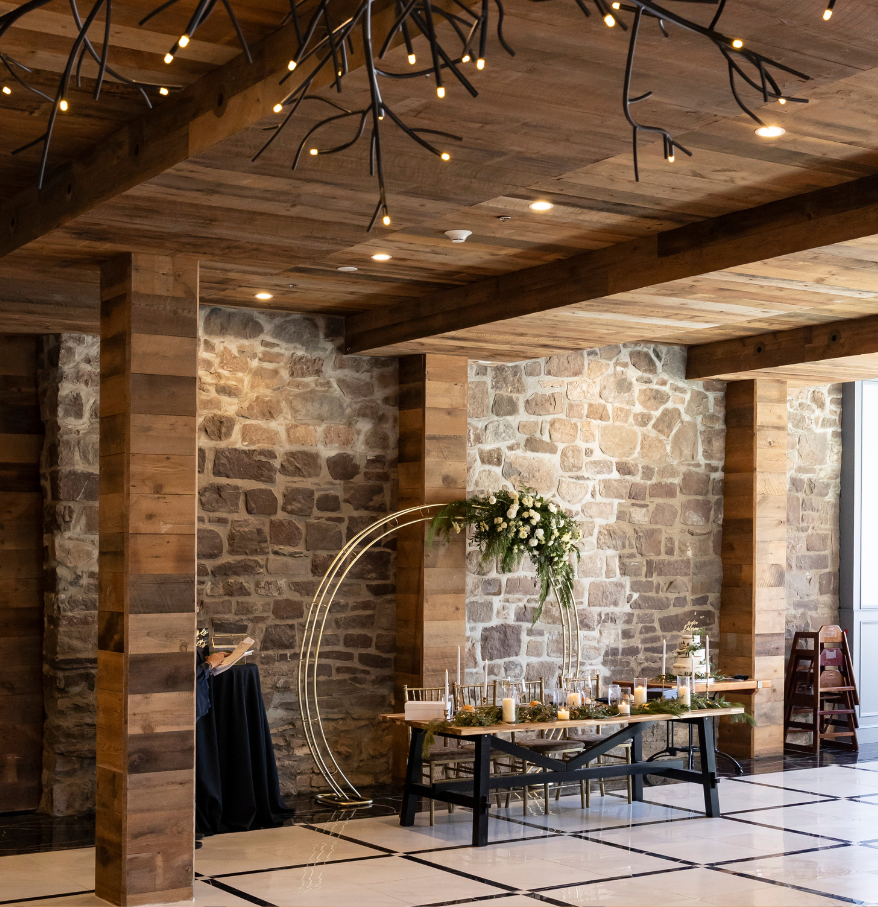 a room with a stone wall and a table with candles and flowers