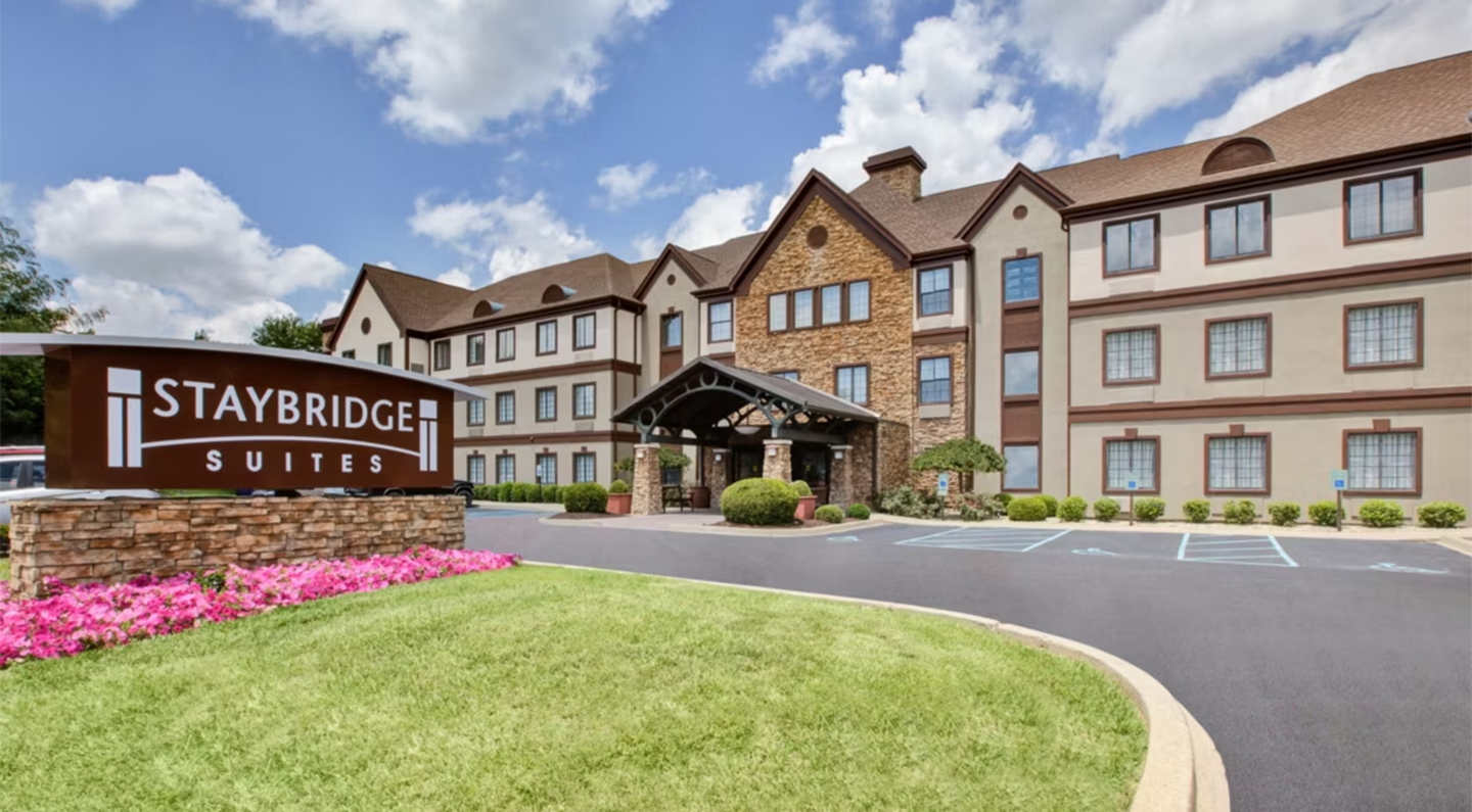 a building with a sign and a lawn