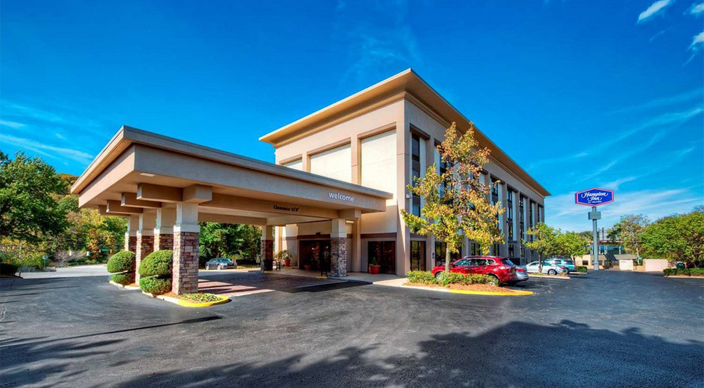 a building with a parking lot and cars parked in front