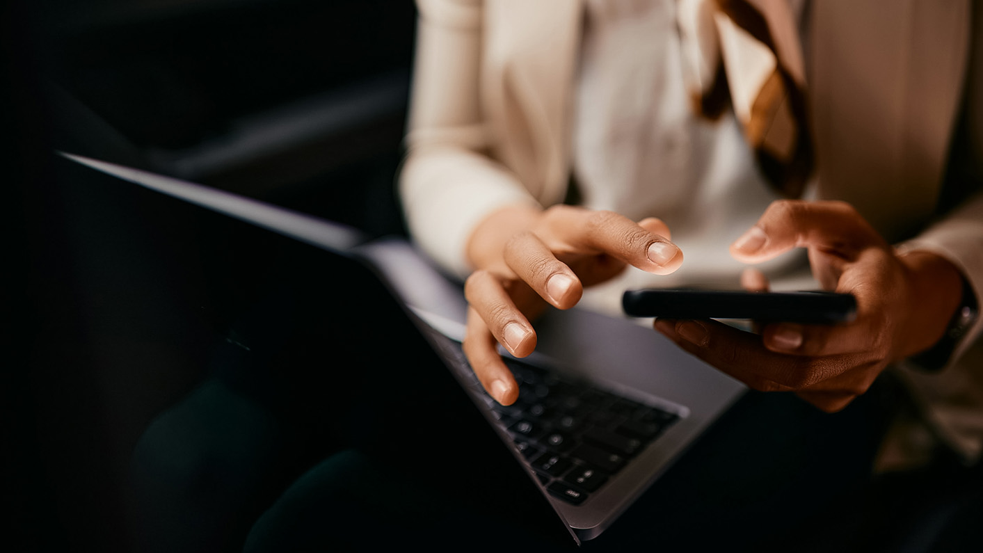 a person using a laptop and a phone