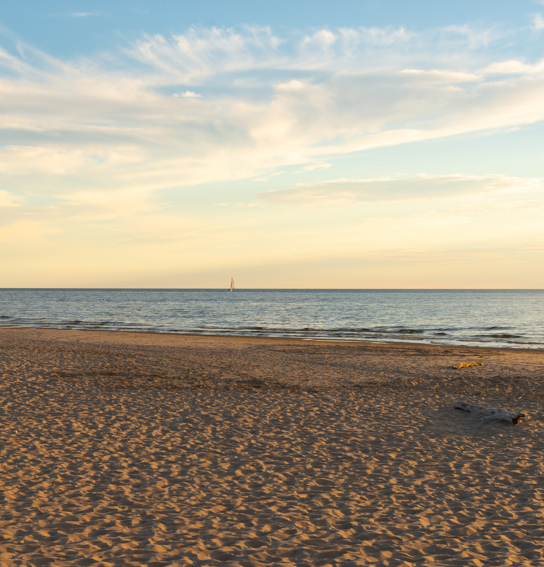 a beach with a lighthouse in the distance