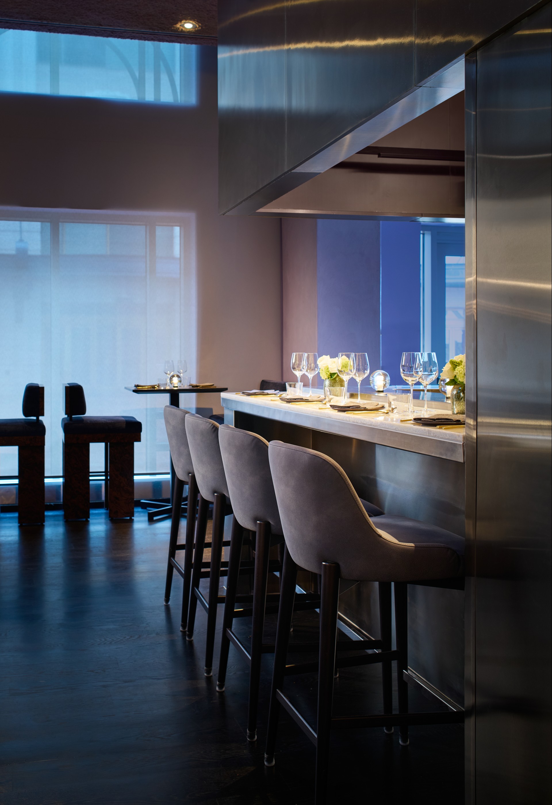 a bar with chairs and glasses on it