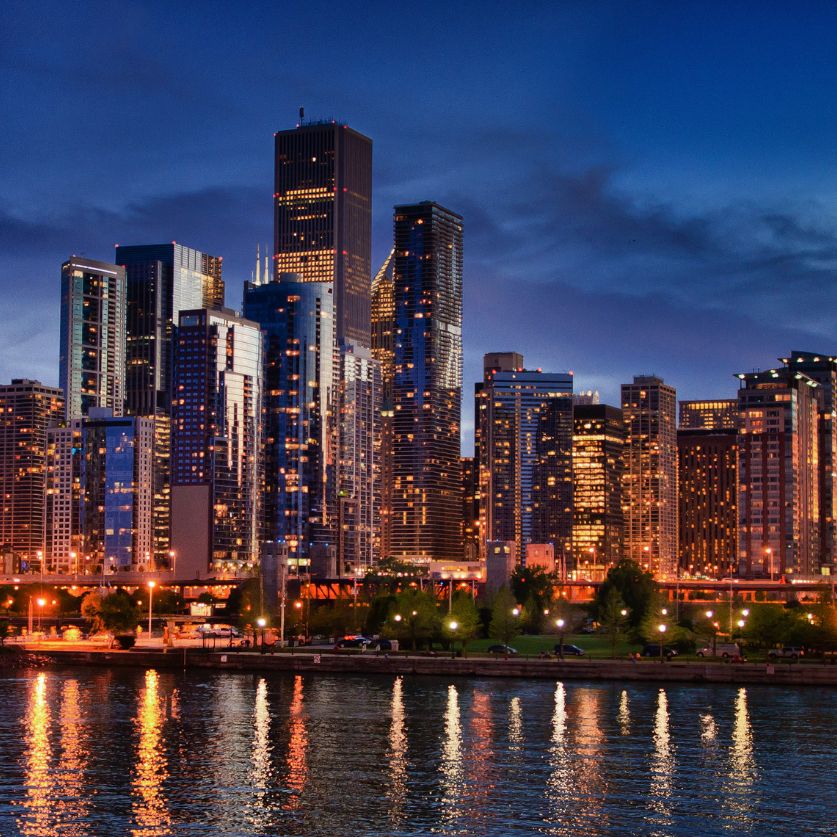 a city skyline with lights on the water