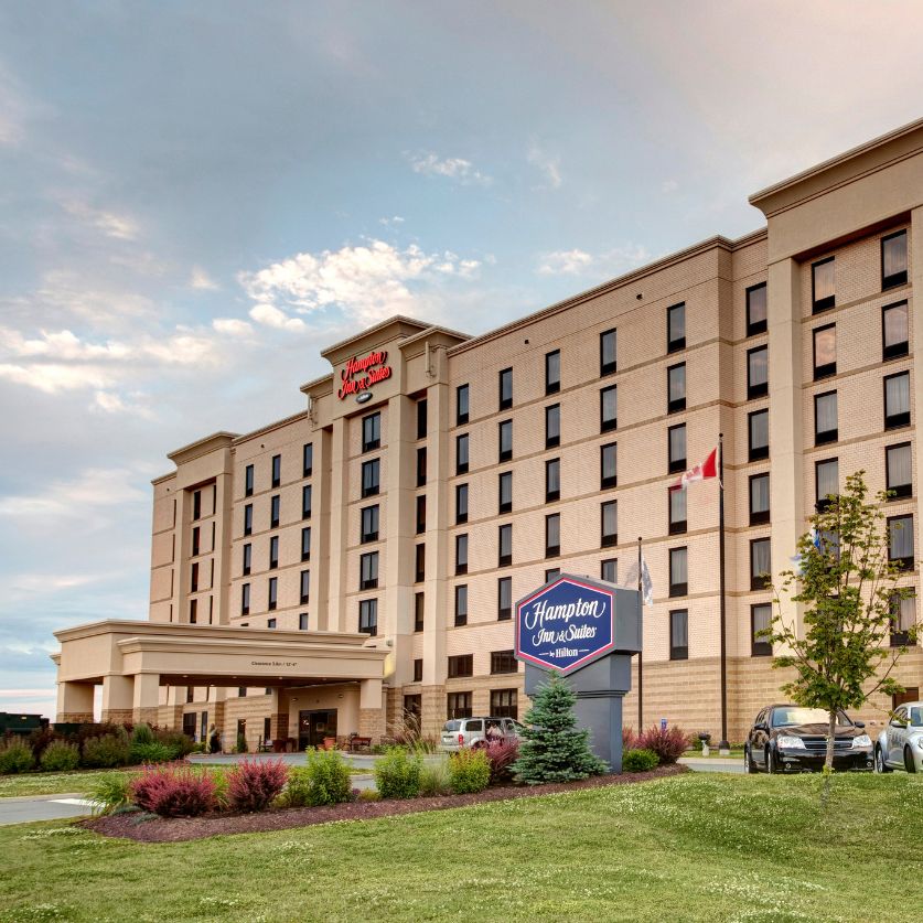 a large building with a sign and cars parked in front of it