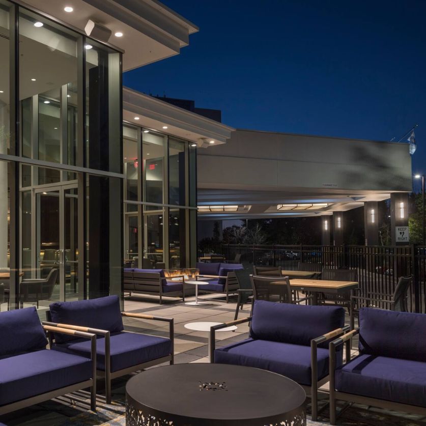 a patio area with chairs and tables outside of a building