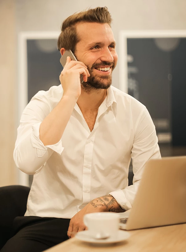 a man in a white shirt talking on a cell phone