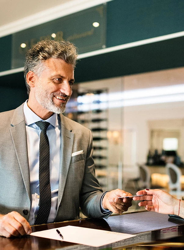 a man in a suit handing a card to a woman