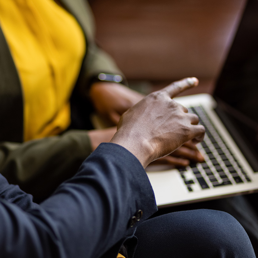 a man and woman sitting and using a laptop