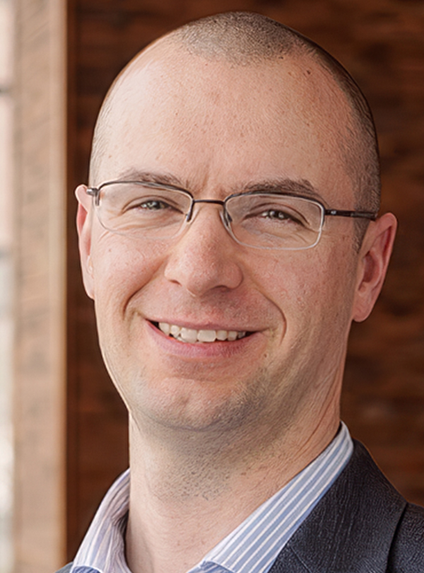 a man wearing glasses smiling