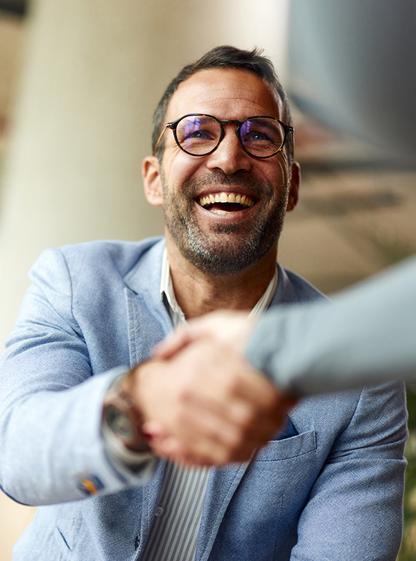 a man in glasses shaking hands with another man