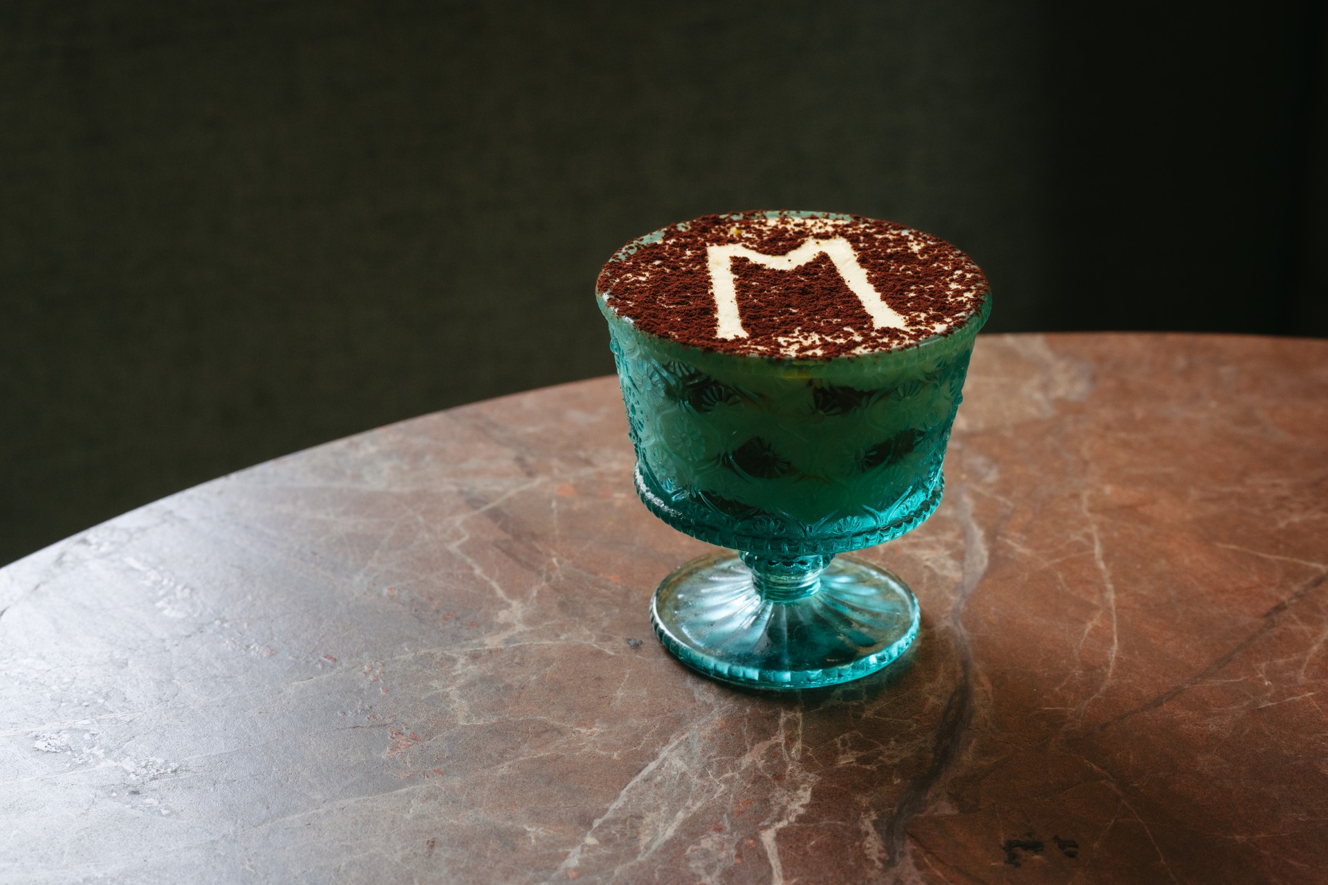 a blue glass with a letter on it