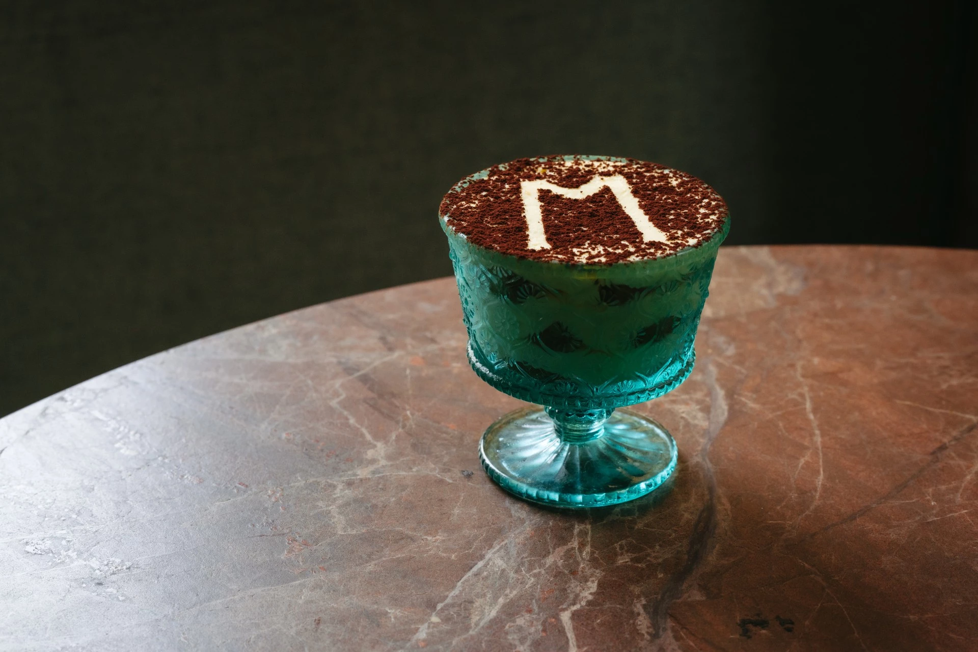 a blue glass with a letter on it