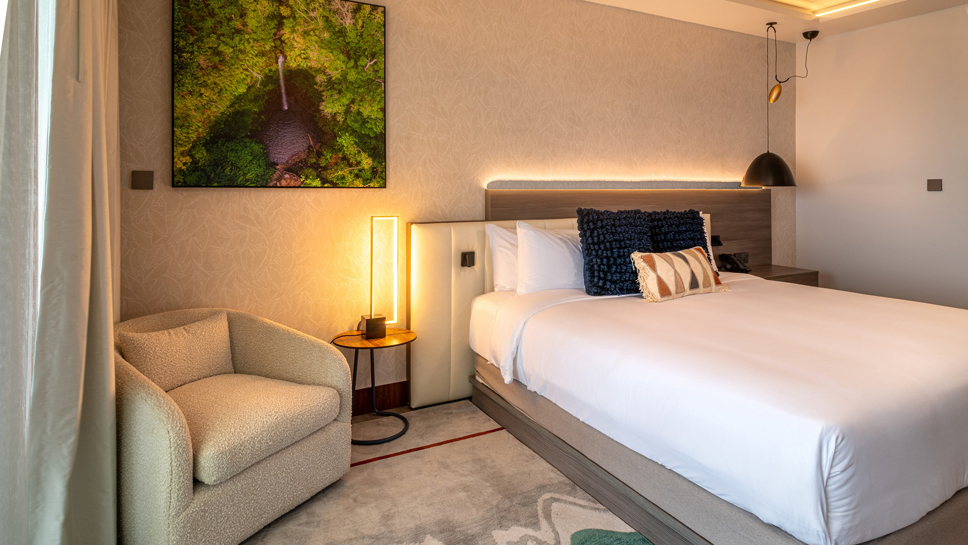 a bed with pillows and a lamp in a room