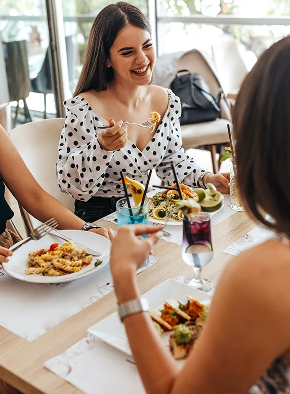 a group of women sitting at a table eating food