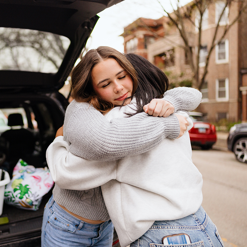 two women hugging in the back of a car