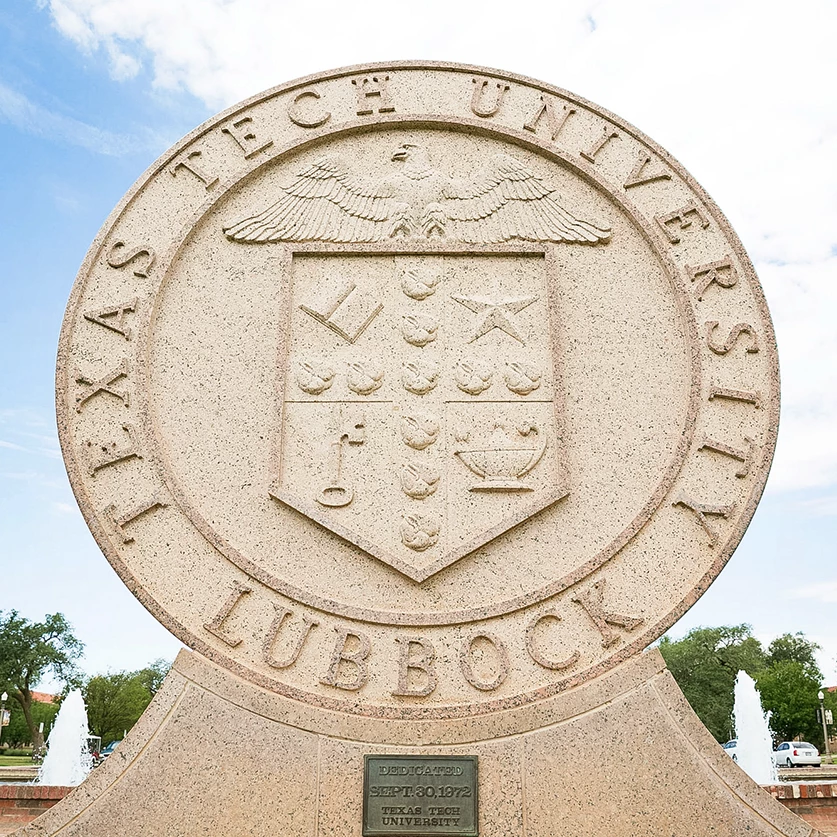a stone statue with a crest and text