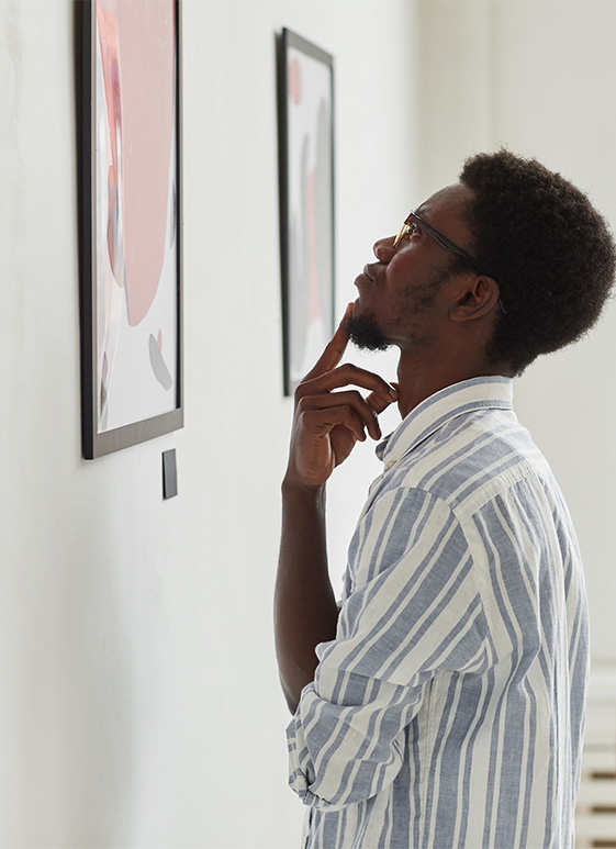 a man looking at a picture on the wall