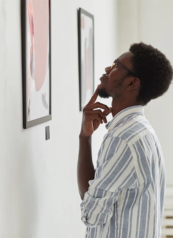 a man looking at a picture on the wall