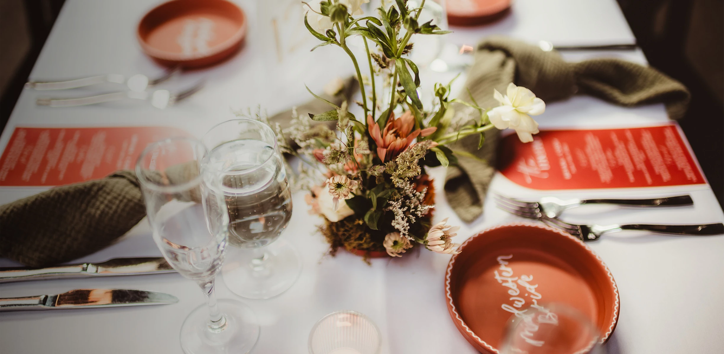 a table with flowers and glasses