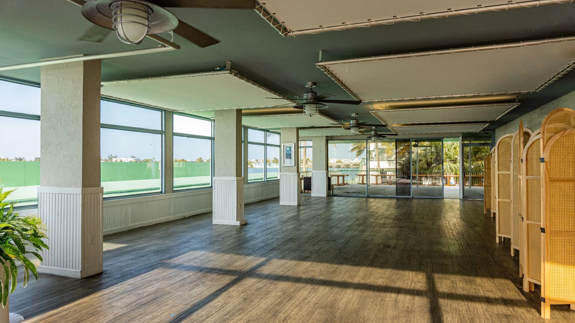 a large room with ceiling fans and windows