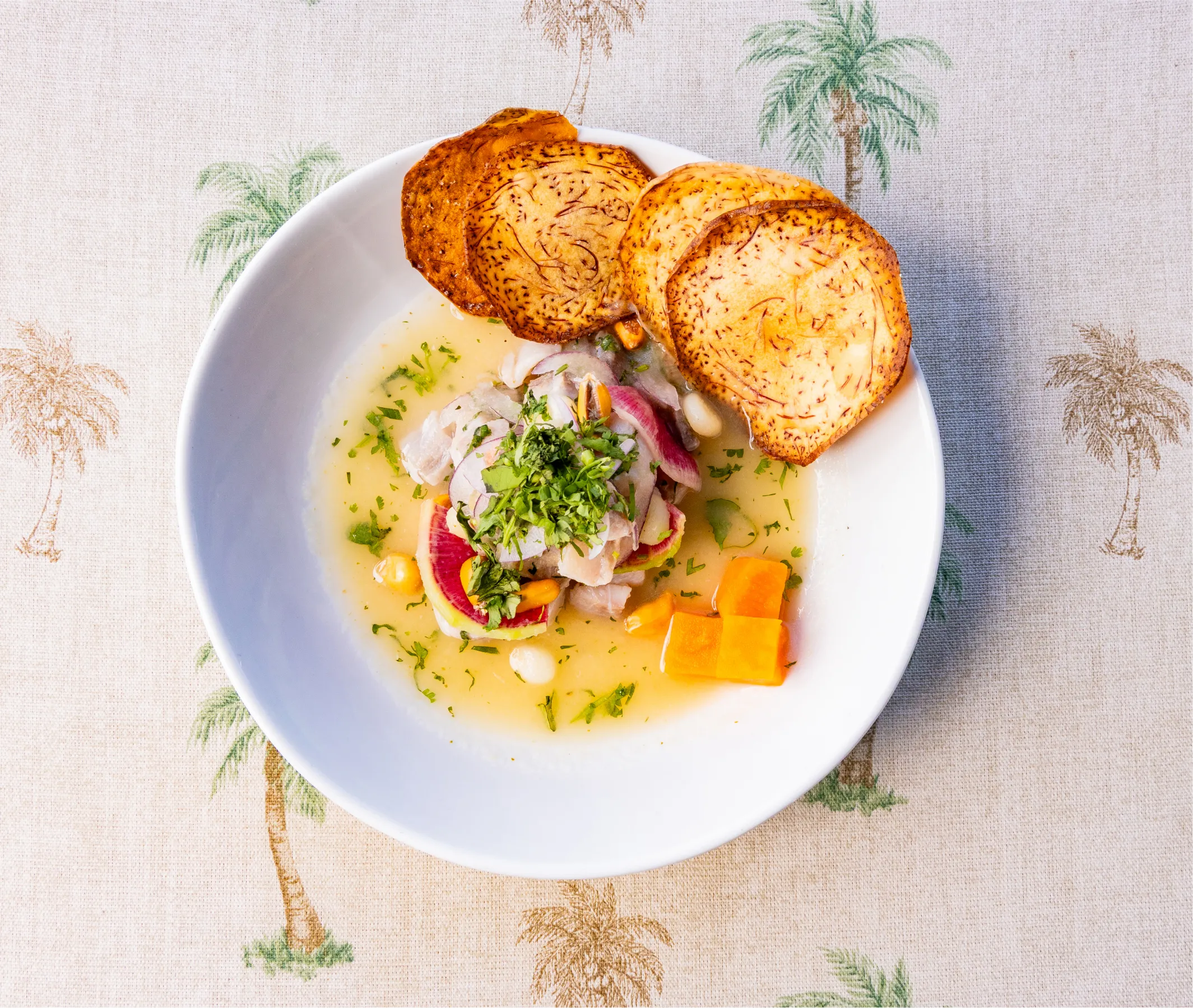 a plate of food with chips on a tablecloth