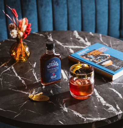 a glass of liquid and a book on a marble table
