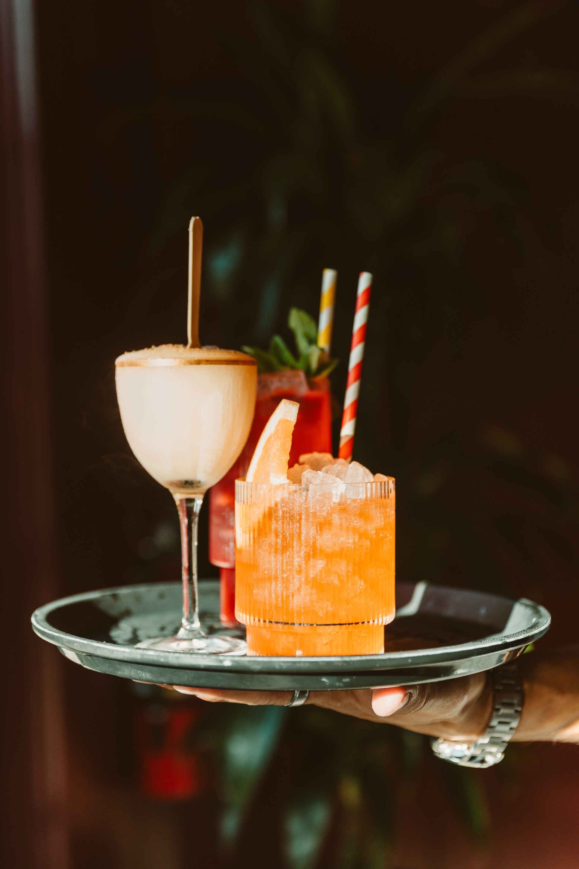 a hand holding a tray of drinks