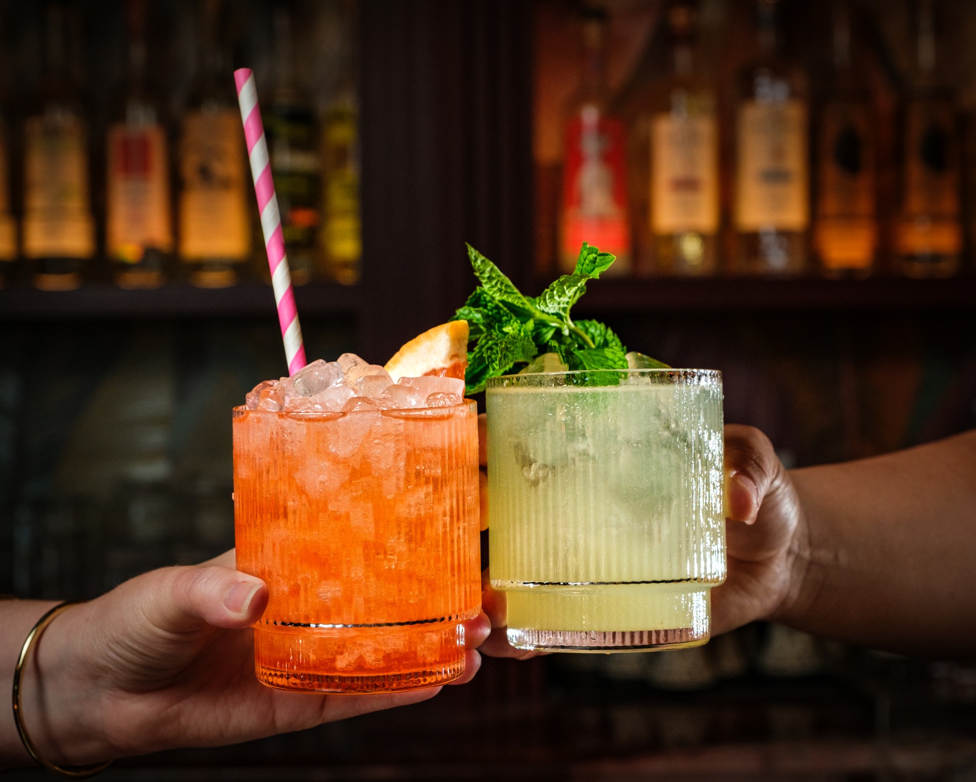 two hands holding up two drinks