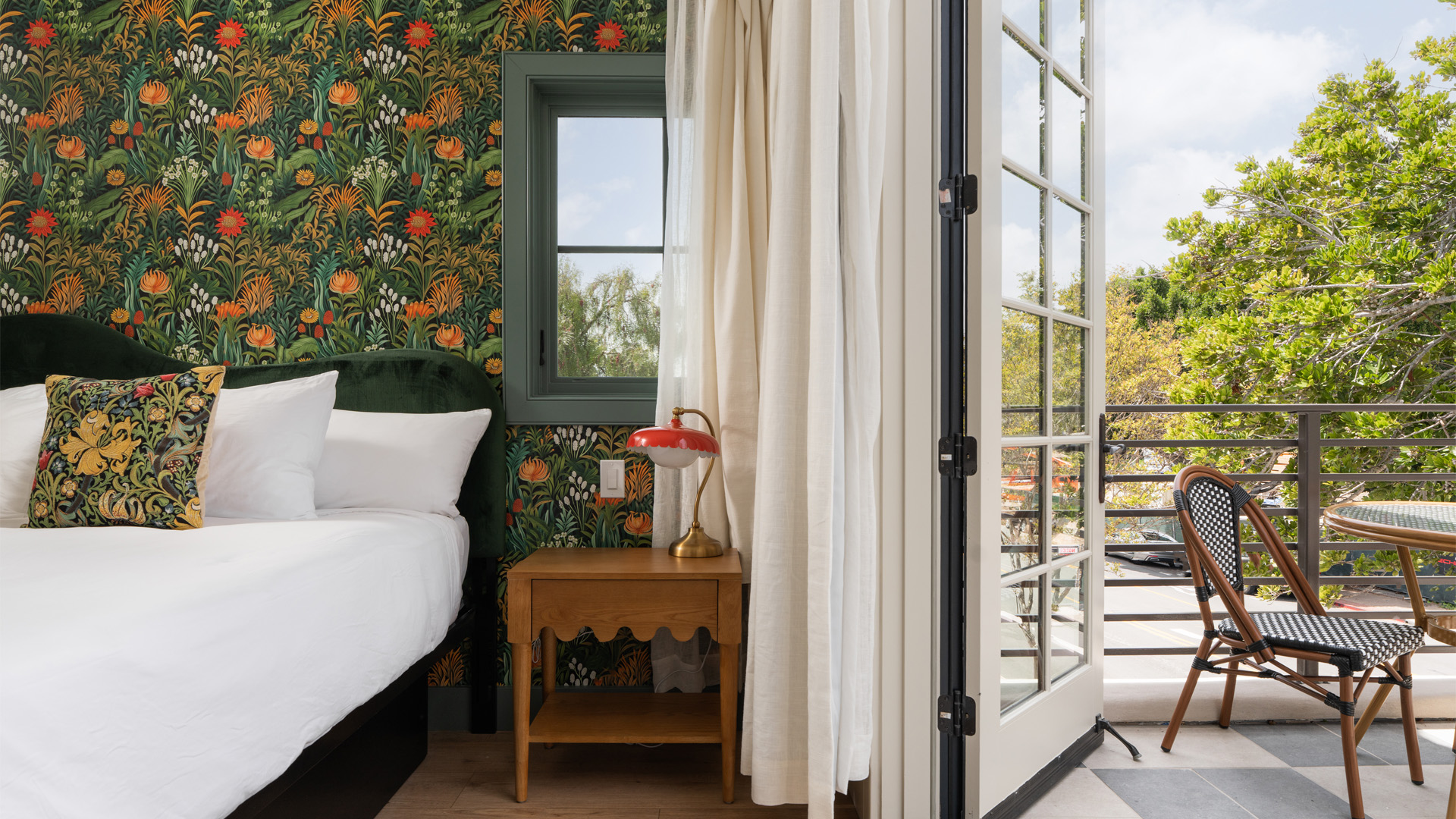 A guest room with a bed, nightstand, and balcony access