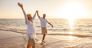 a man and woman dancing on a beach