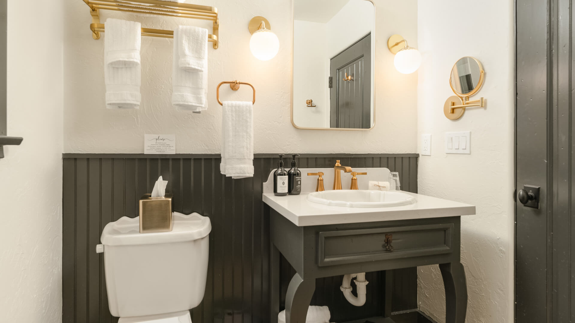 A clean and stylish bathroom with gold fixtures and dark wood accents.