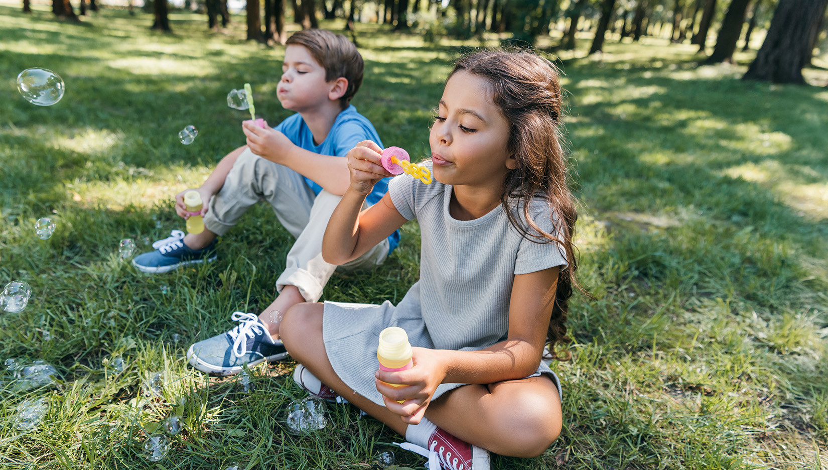 a boy and girl blowing bubbles