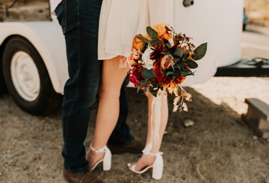 a bride and groom on their wedding day holding a bouquet of flowers
