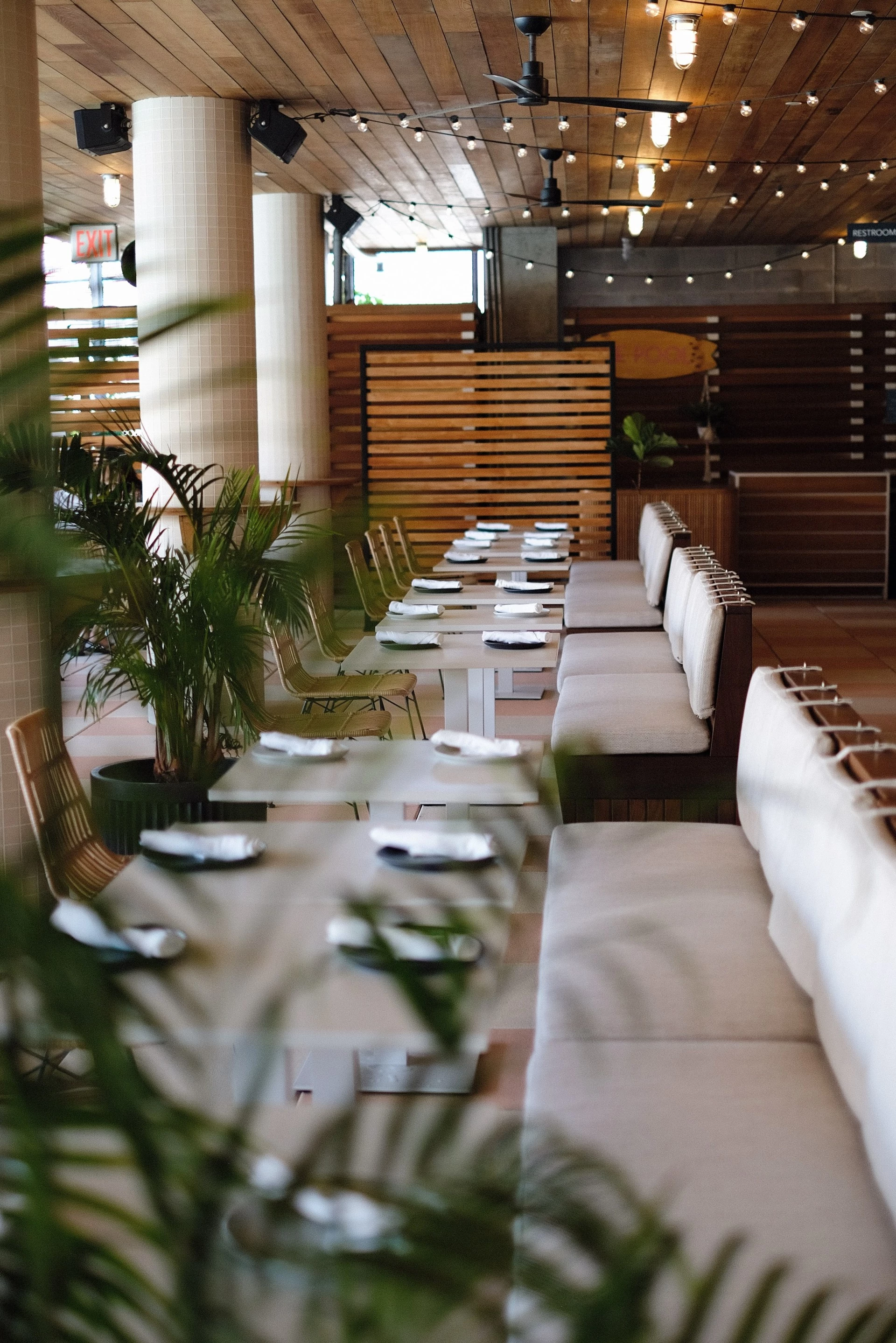 a long table with white chairs and plates on it