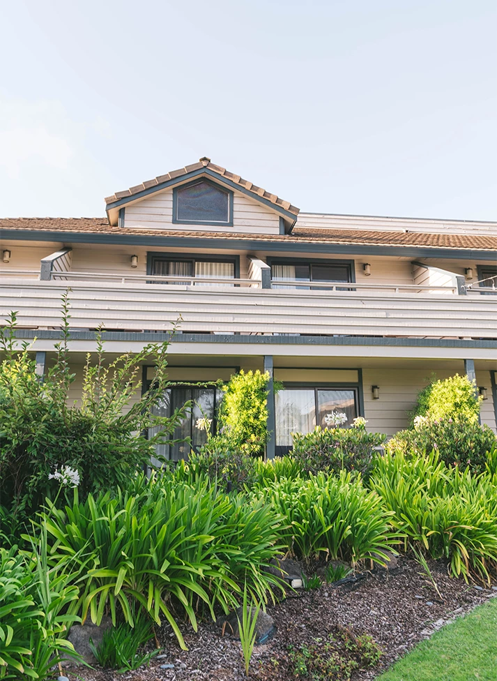 a building with a balcony and plants