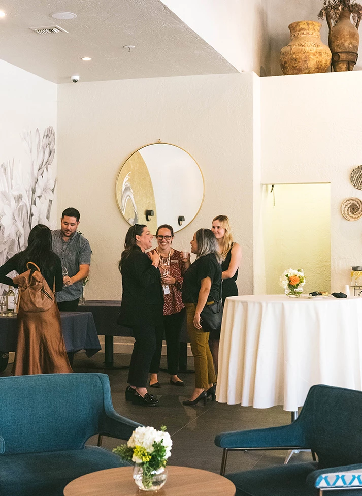 a group of people standing around a table