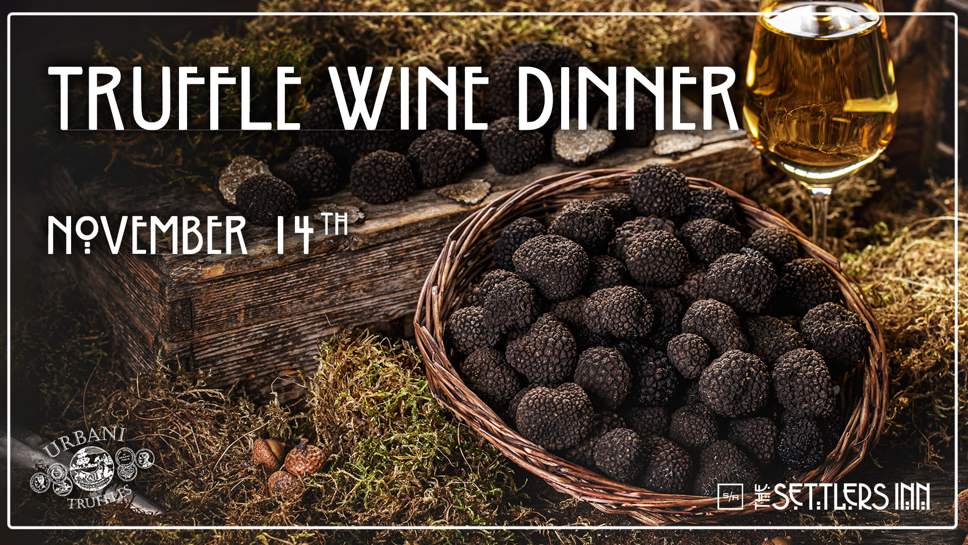 a basket of black truffles next to a glass of wine