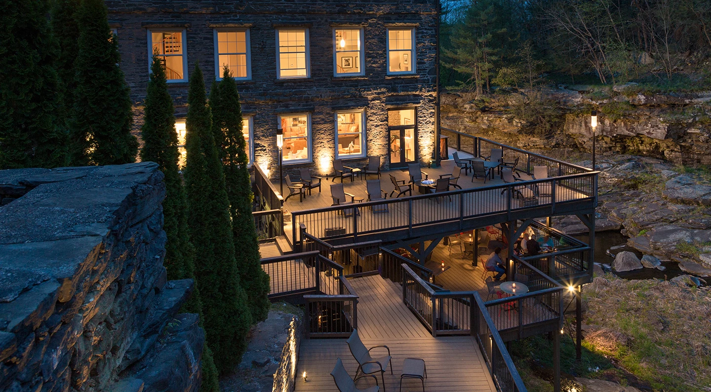a building with a deck and chairs and trees
