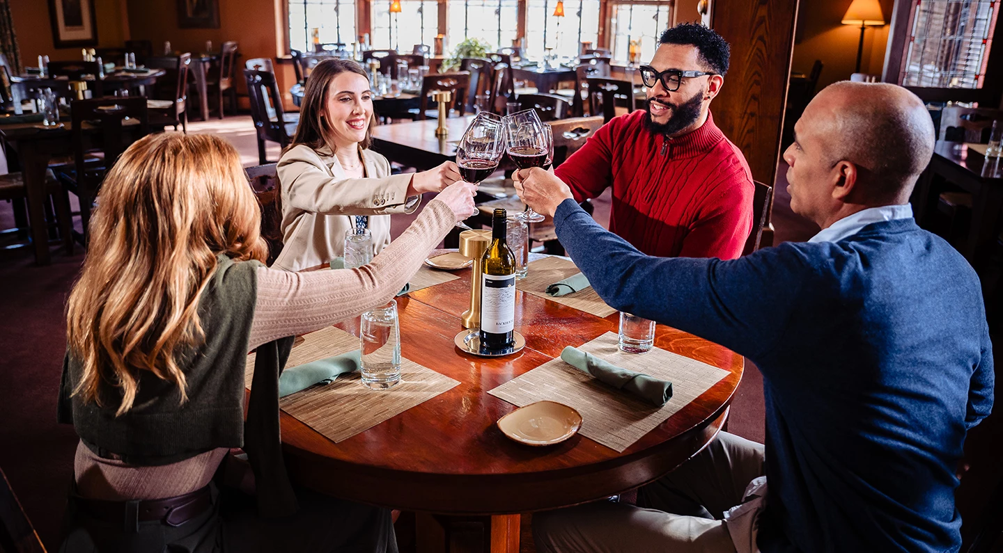 a group of people clinking glasses at a table