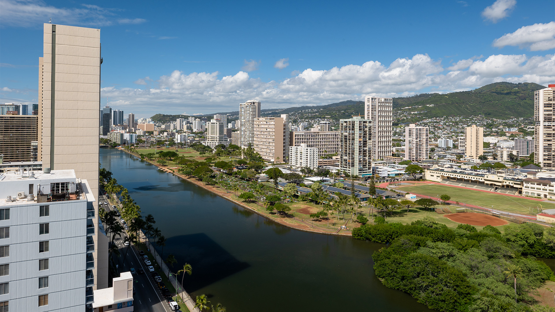 A cityscape with a river and mountains in the background