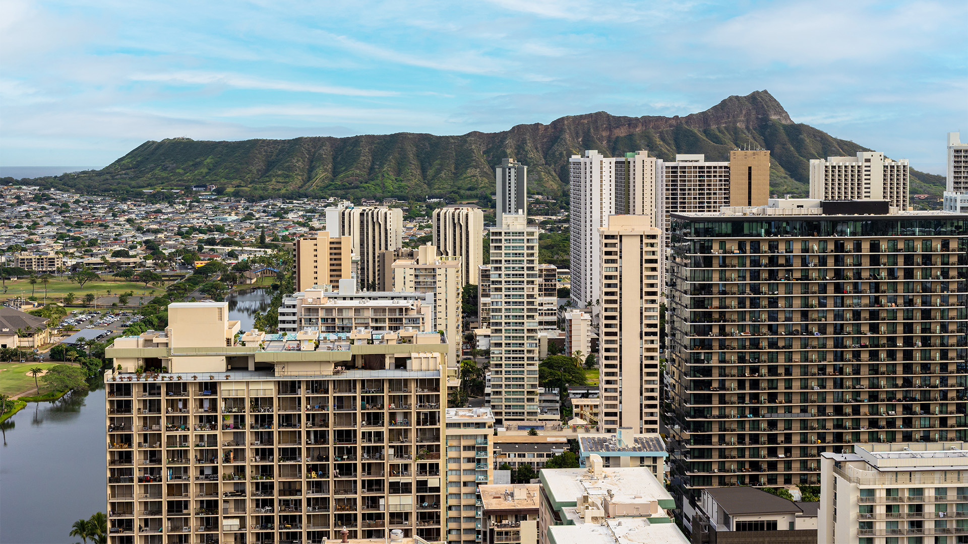 A cityscape with high-rise buildings and a mountain in the background.