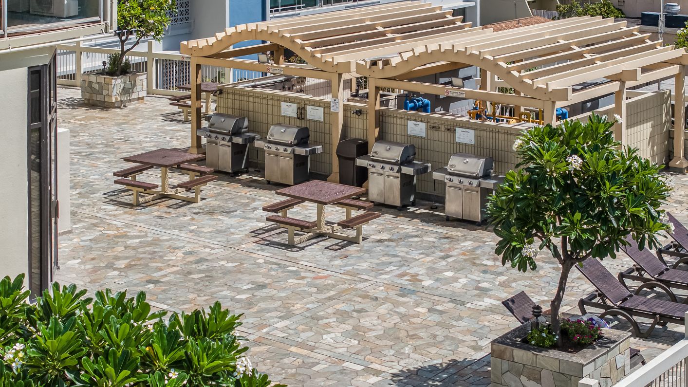 a barbecue area with benches and tables