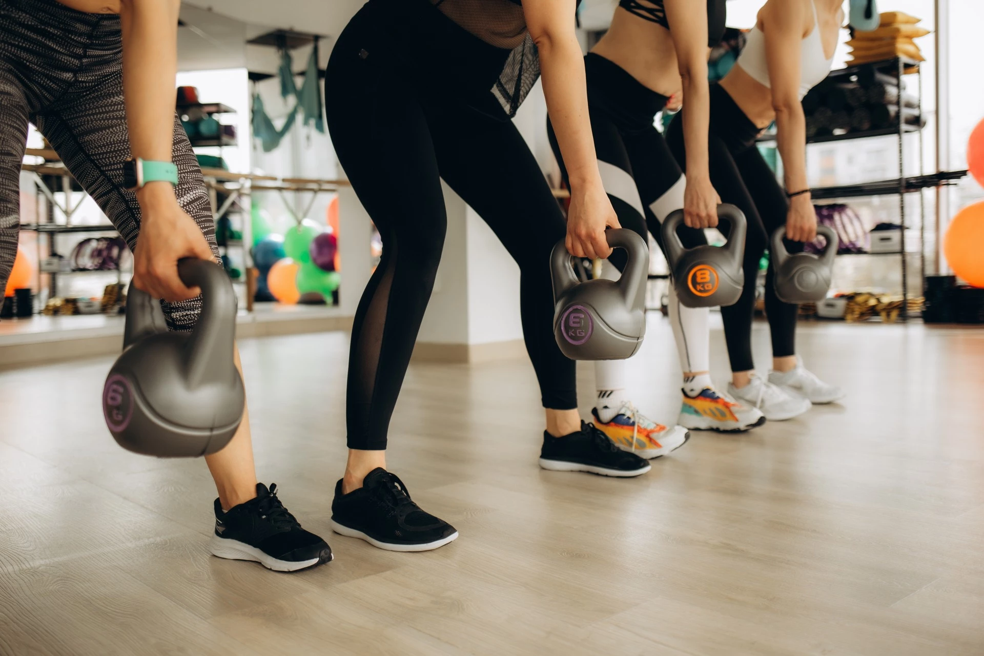 a group of people holding kettlebells