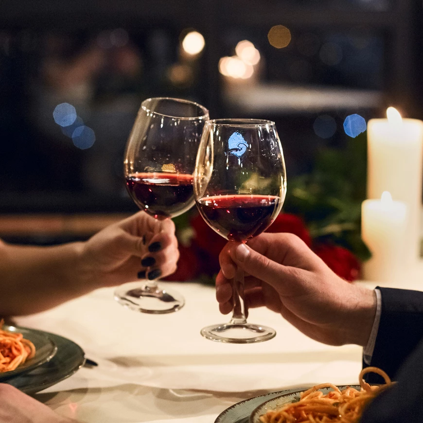 a couple holding wine glasses at a table